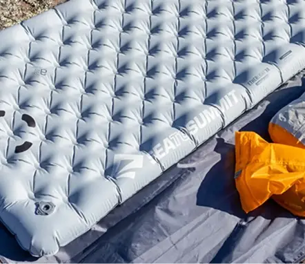 Compact sleeping bag rolled out on a camping mat